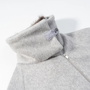 Close-up of light gray faux fur jacket collar with silver zipper and buckle detail