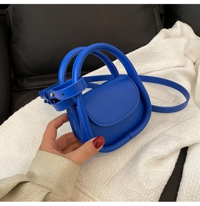 Détail de la mini sacoche bleu Klein avec poignée épaisse et texture en similicuir