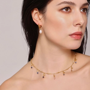 Golden freshwater pearl necklace and zircon earrings set on a model in studio light