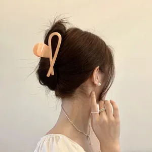 Elegant apricot pink large hair claw clip with cross design for minimalist hair styling