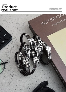 Stacked men's braided leather bracelets featuring skull, music note and infinity metal charms