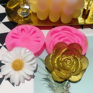 Detail of pink silicone sunflower and daisy molds with finished white floral crafts
