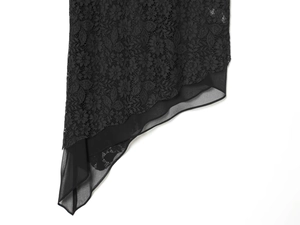 Detail of black floral lace fabric with asymmetric hem and sheer chiffon stitching