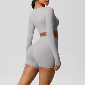 Zijaanzicht van de grijze yogaset met high-waist short en crop top met lange mouwen