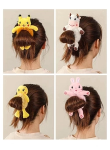 Détail d'élastiques en peluche avec ours et lapin mignons sur un chignon de cheveux