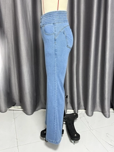 Detail of high-waisted elastic waistband with multi-row stitching on slim flare jeans