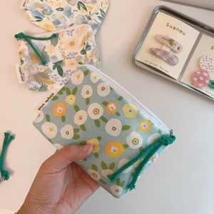 Detailed macro of a floral cotton zip pouch featuring blue fabric with yellow flowers