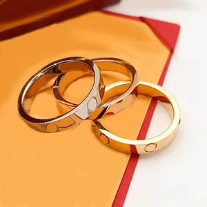 Detailed view of three titanium steel screw rings in gold, silver, and rose gold finishes