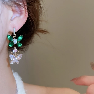 Detail of silver needle gold butterfly earrings with green zircon and pink heart crystal