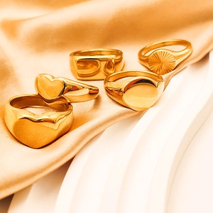 Detail of 18K gold plated heart and geometric signet ring set on white pedestal