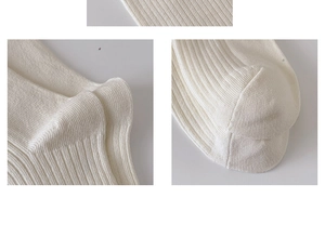 Detailed macro view of cream-white knit ribbed texture and toe seam on cotton socks