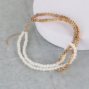 Close-up of gold beads and faux pearls interlocking with adjustable lobster clasp