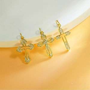 Detailed view of three gold-plated cross pendants with cubic zirconia for DIY necklaces
