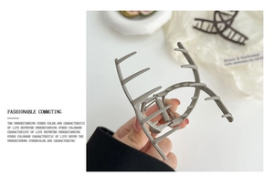 Close-up of matte grey metal hair claw clip with cross-claw design and sturdy spring