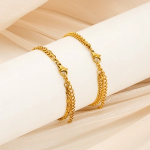 Détail d'un bracelet double couche perlé doré avec fermoir sur fond de soie blanche élégante