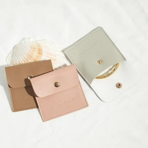 Detail of PU leather jewelry pouches in soft pink and mocha with gold snap buttons