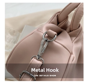 Close-up of shiny silver hardware hook and stitching on pink leather crossbody bag