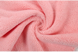 Nahaufnahme von weichem rosa Korallenvlies-Stoff mit dicker Plüsch-Spiralstruktur
