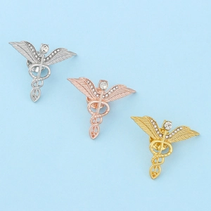 Drei Caduceus Medizinnadeln in Silber, Gold und Roségold mit funkelnden Strasssteinen