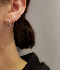Macro shot of S925 sterling silver double-layered round hoop earrings on model ear