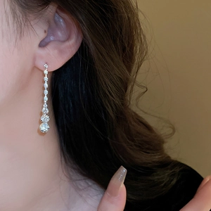 Détail de boucles d'oreilles géométriques de luxe avec diamants brillants sur métal argenté