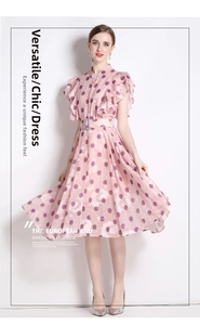 Detail von rosa Polka-Dot-Chiffonkleid mit Rüschenärmeln und passendem Taillengürtel
