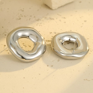 Minimalist silver irregular hollow round stainless steel earrings on beige stone