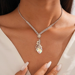 Gros plan sur le collier en Y argenté avec pendentif cœur étincelant et diamants pavés