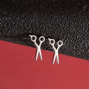 Macro view of silver stainless steel scissors studs on black leather and red background