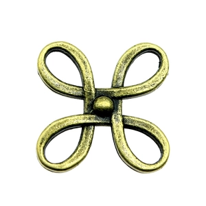 Macro detail of alloy Chinese knot pendant with antique bronze finish on white background