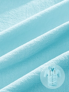 Macro shot of breathable light blue linen fabric texture on men's hooded short sleeve shirt