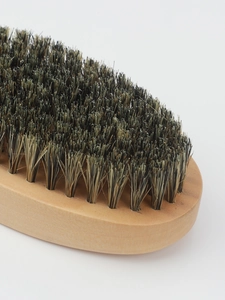 Macro detail of natural wooden beard brush with dense bristles for grooming