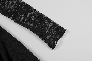 Detailed close-up of black floral lace fabric with intricate hollow patterns on the dress
