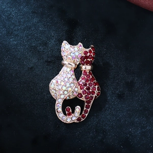 Exquisite gold-plated dual cat brooch with iridescent white and deep red crystals