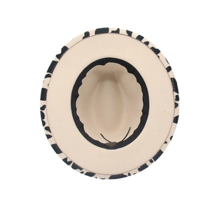 Vertical view of a wide brim jazz fedora with cow print edges and interior sweatband