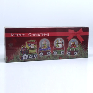 Close-up of a Christmas train set gift box with four musical snow globes and characters