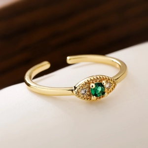 Macro shot of 18K gold ring featuring emerald stone and vintage beaded texture