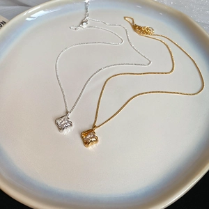 Detailed macro view of 18k gold plated and silver square pendants with zircon stones