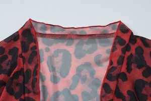 Detail shot of sheer mesh fabric with red leopard print showing neckline and seam quality