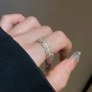 Close-up of 18k gold plated ring featuring staggered rectangular and round cubic zirconia