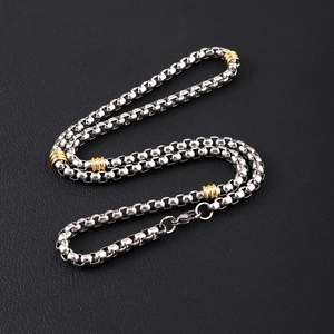 Two-tone silver and gold stainless steel square box chain necklace on black leather