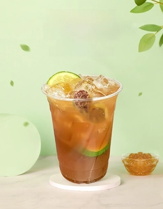 Macro shot of thick transparent PET plastic cup with fresh iced tea and lime slices