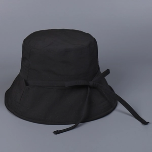 Détail d'un chapeau de soleil en nylon noir à séchage rapide avec large bord et nœud plat