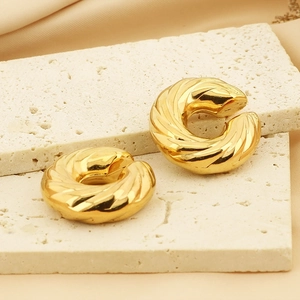Macro shot of 18k gold hollow donut C-shaped clip earrings with elegant spiral texture