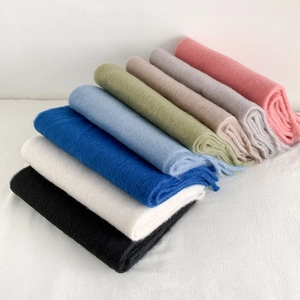 Thick cashmere-like scarves in eight assorted colors stacked for winter warmth