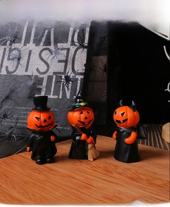 Detailed view of Halloween resin pumpkin figurines in a festive interior tabletop setting
