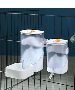 Détail du distributeur automatique d'eau et de nourriture suspendu à une cage noire