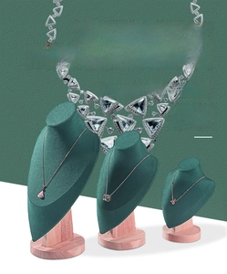 Three-tier dark green velvet necklace busts with light wood base in different heights