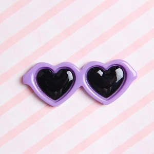 Macro shot of a purple heart-shaped resin accessory for DIY plush doll glasses