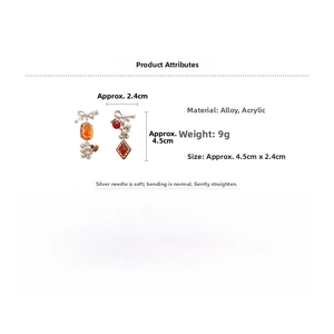 Detail view of asymmetric bow earrings with orange beads and silver needles